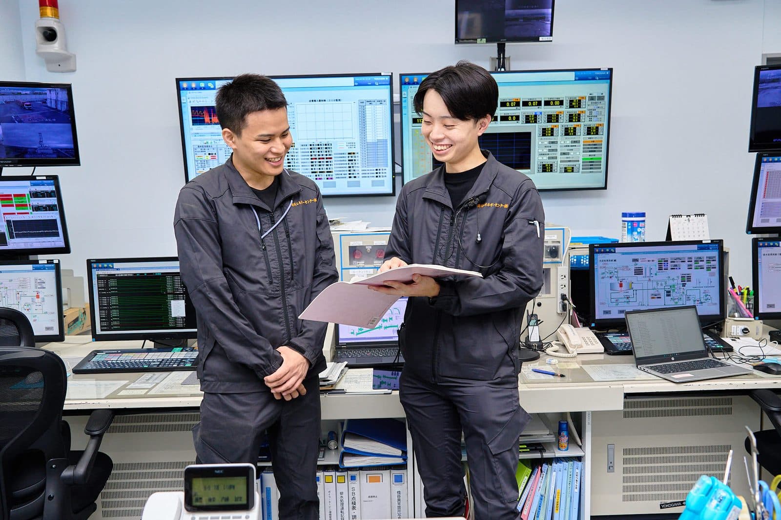 発電所制御室で打ち合わせる社員