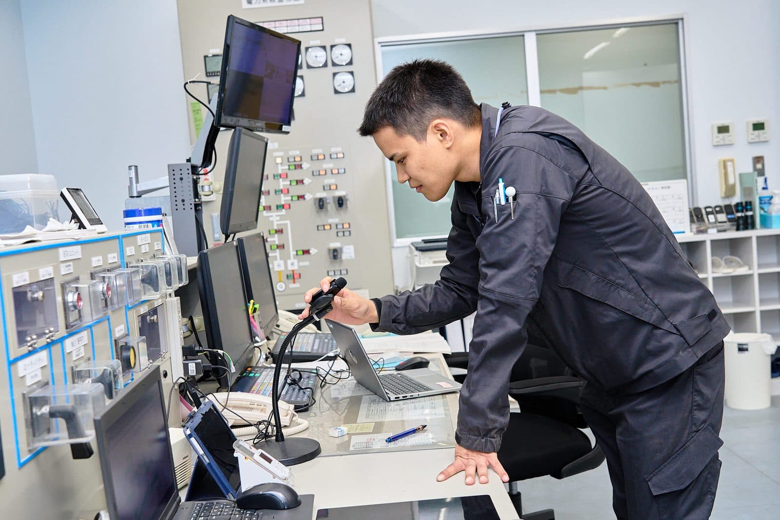 制御室のモニター前で確認作業をする社員