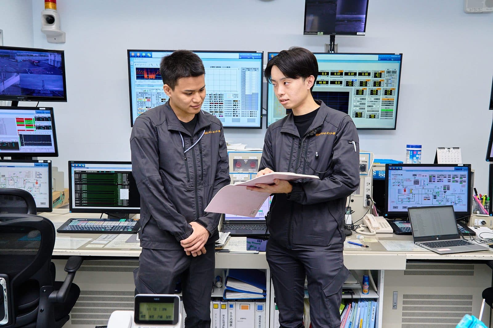 制御室で打ち合わせる社員
