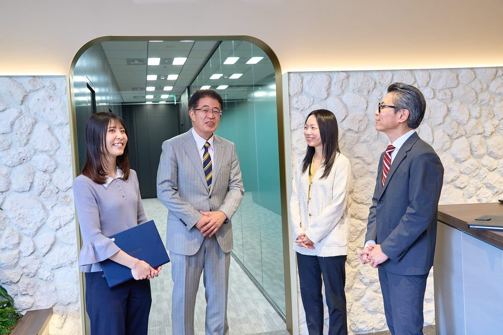 石壁の前で談笑する社員